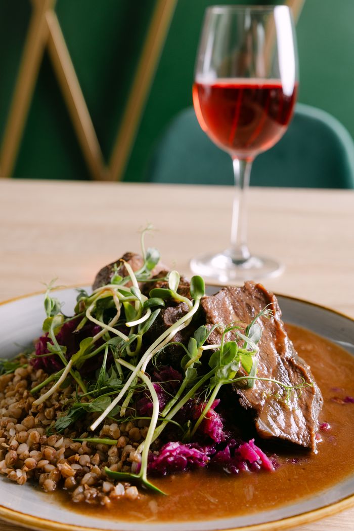 Savor a gourmet beef meal paired with fine red wine in a sophisticated dining atmosphere.